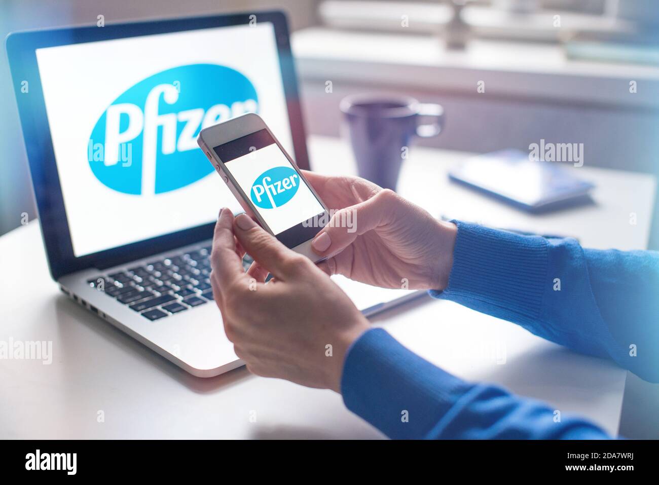 Polen, Posen, 10.11.2020 Logo des Pharmaunternehmens, das den kovidierten Impfstoff auf dem Smartphone-Bildschirm produzierte. Die Frau hat ein Pfizer-Logo Stockfoto