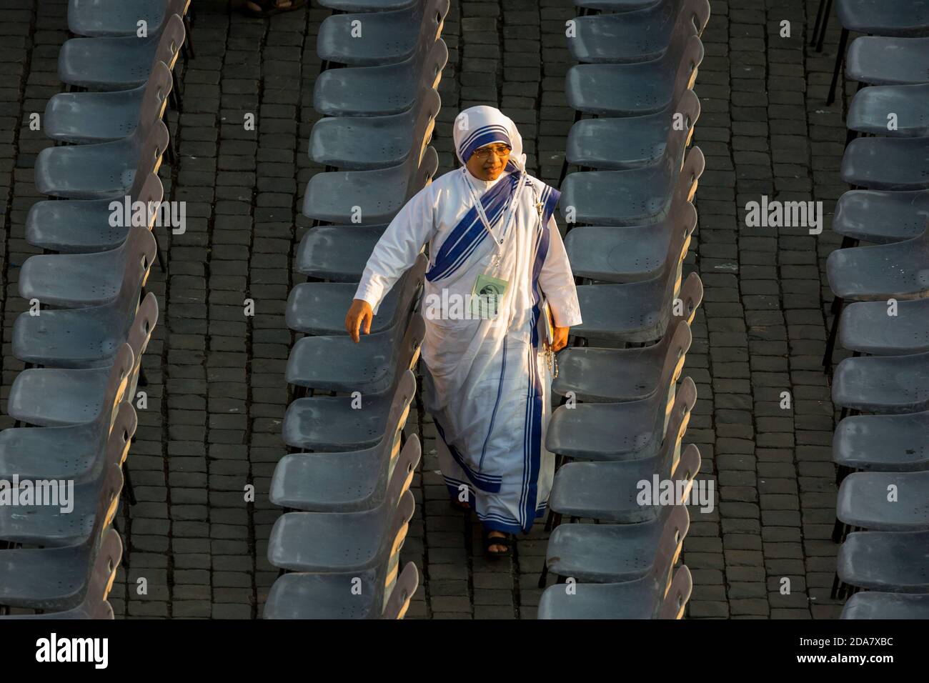 Eine Nonne des Ordens von Mutter Theresia von Kalkutta Spaziergang zwischen Reihen von leeren Sitzen auf dem Petersplatz Stockfoto