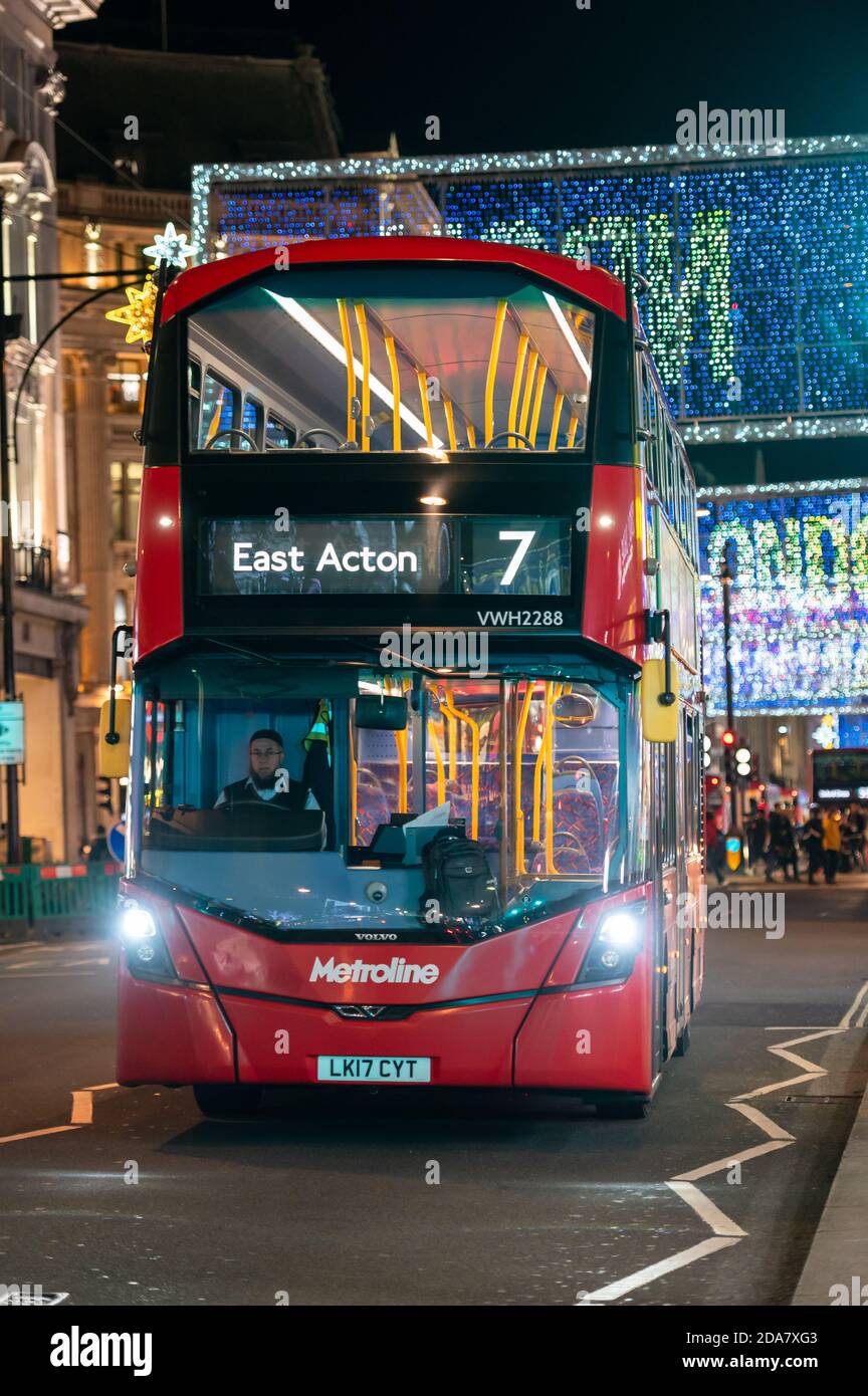 LONDON - 3. NOVEMBER 2020: Roter London Doppeldeckerbus mit Oxford Street beleuchtete Weihnachtsdekorationen im Hintergrund Stockfoto