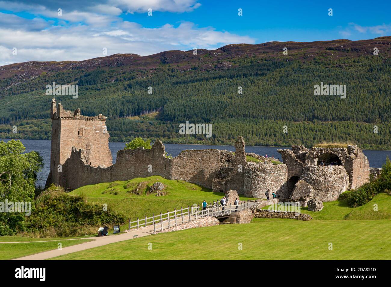 Touristen besuchen Ruinen von Urquhart Castle entlang der Ufer des Loch Ness, Highlands, Schottland Stockfoto