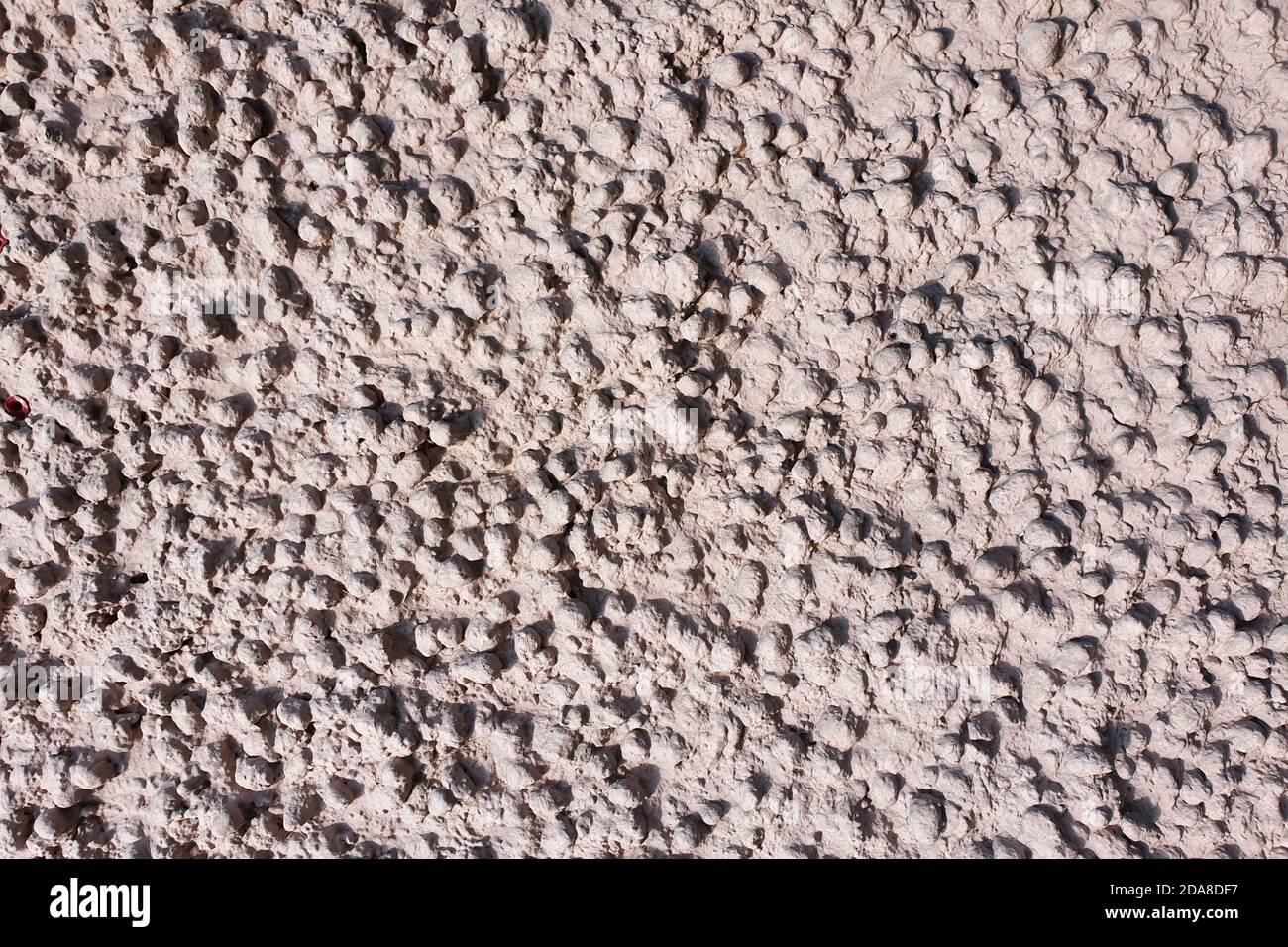 Blähton Beton Textur. Hellrosa Reliefputz, bestehend aus Blähton-Steinen. Abstrakter Hintergrund. Stockfoto