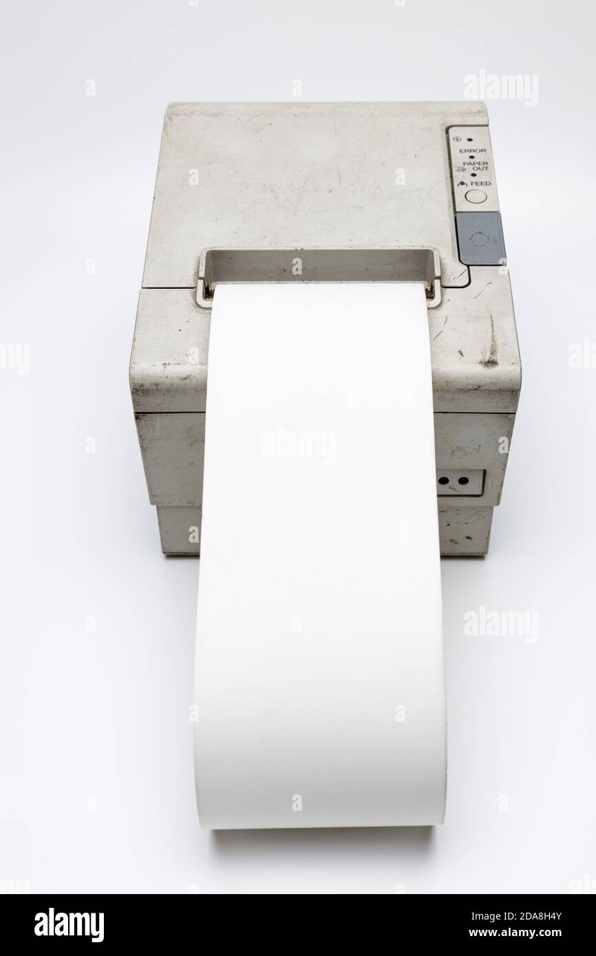 Weißes Thermopapier, das aus einem alten Retro-Belegdrucker herausrollt, dieser alte und gebrauchte Belegdrucker wurde an eine Kasse angeschlossen, ich bin benutzt und di Stockfoto
