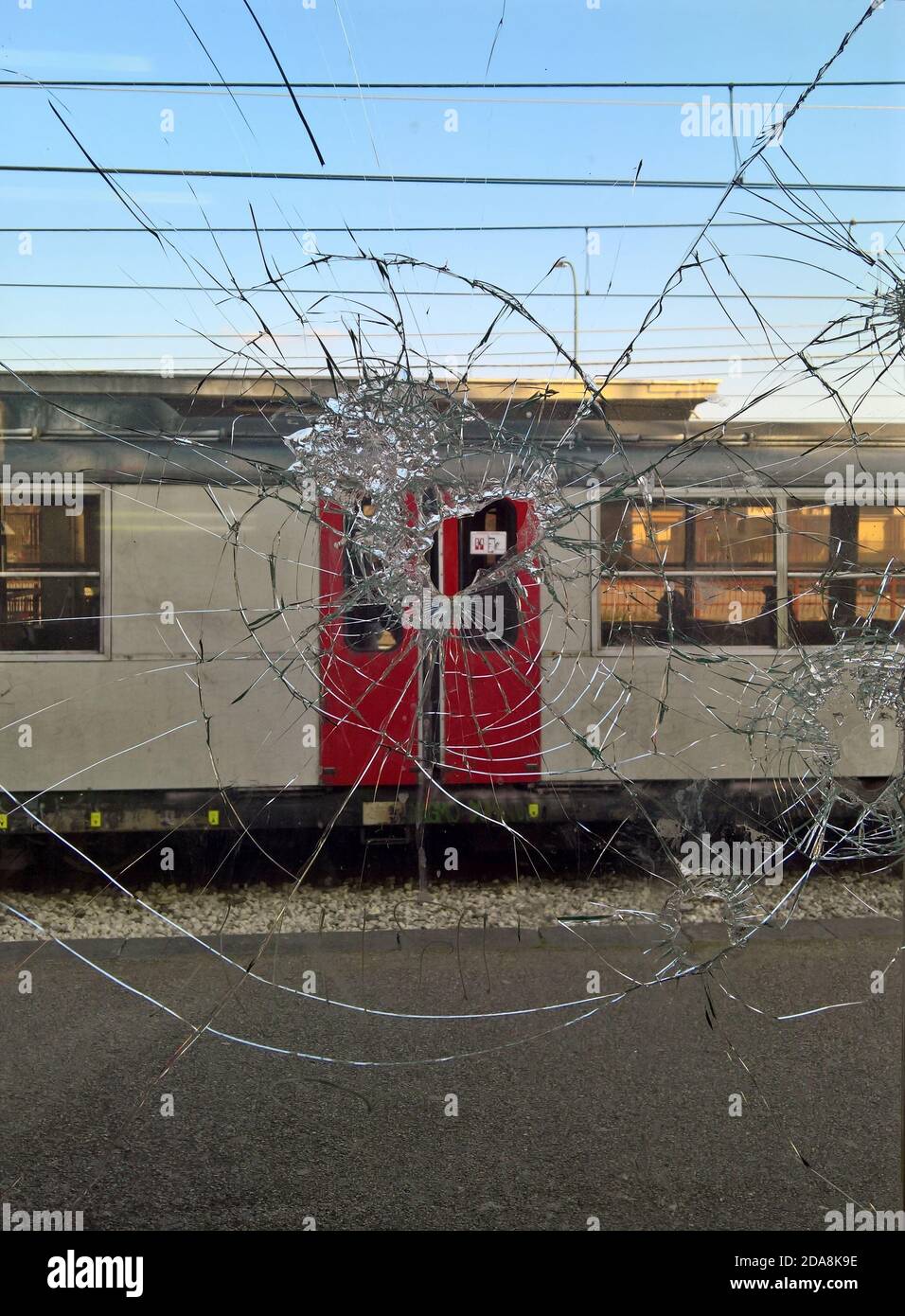 Blick auf einen Zug durch zerbrochenes Glas in einem Fenster In diesem Foto in Süditalien aufgenommen Stockfoto