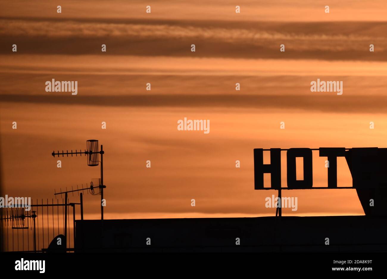 Das Wort Hot steht vor einem orangen Himmel als Die Sonne geht am Ende eines weiteren schönen Tages unter Stockfoto