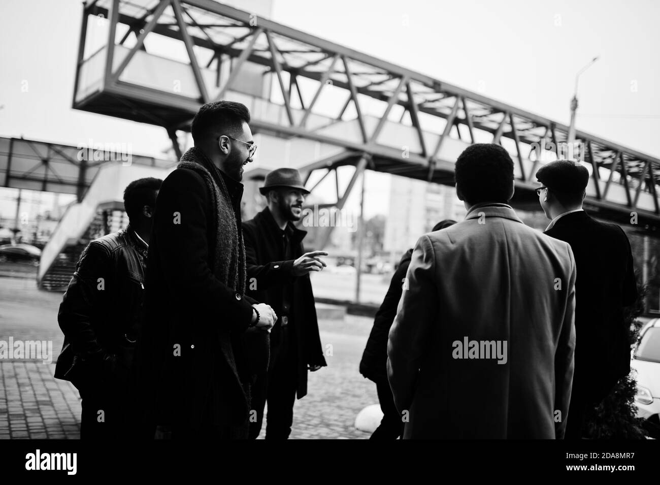 Gruppe von schönen Retro gut gekleideten Mann Gangsters Rauchen im Freien. Multiethnische männliche Junggesellenabschied Mafia Partei. Stockfoto