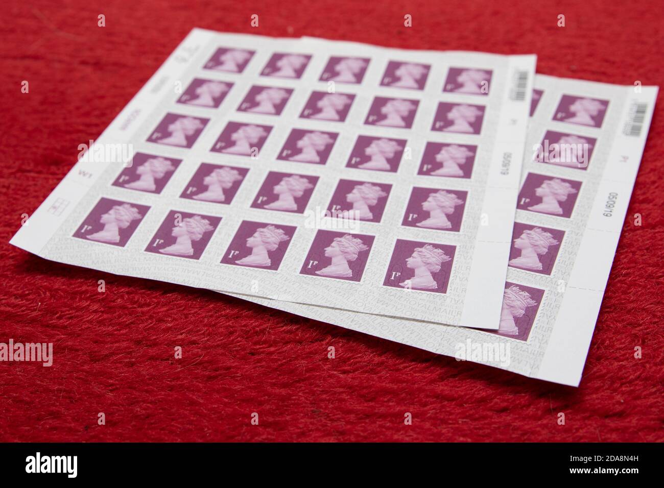 Zwei Blätter mit 1-P Royal Mail Briefmarken Stockfoto