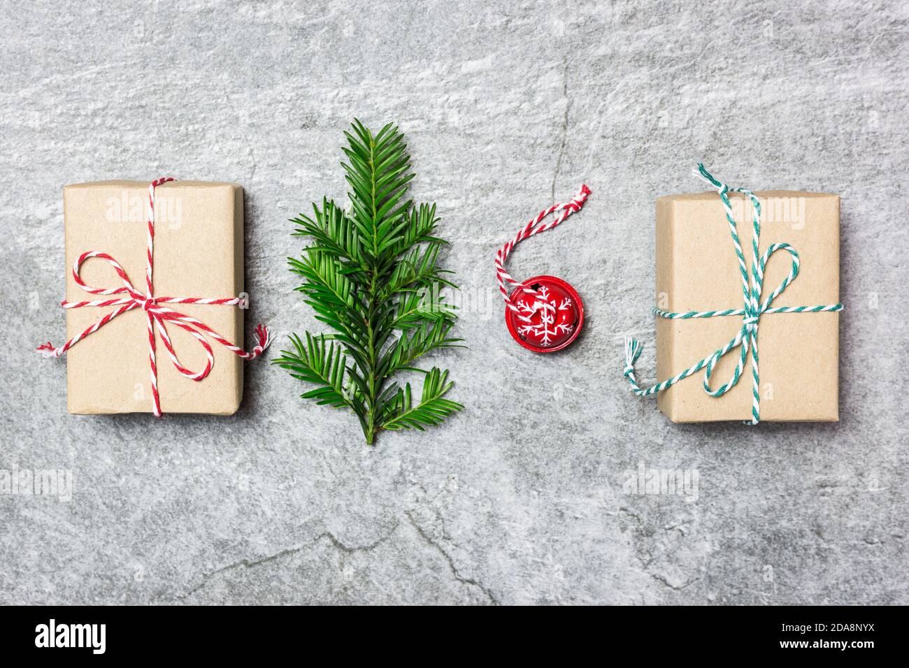 Weihnachtskomposition. Geschenke, immergrüner Baum und roter Weihnachtsschmuck auf grauem Steingrund. Weihnachten, Winter, Neujahr Konzept. Flach auflegen, Oberteil V Stockfoto