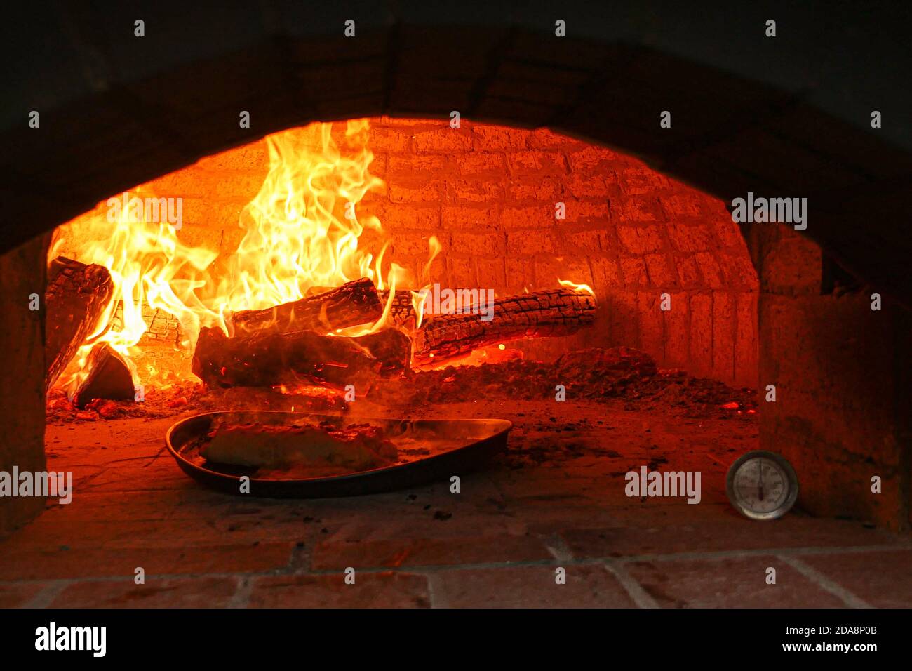 Kamin brennend mit Tablett von Lebensmitteln Kochen im Vordergrund. Stockfoto