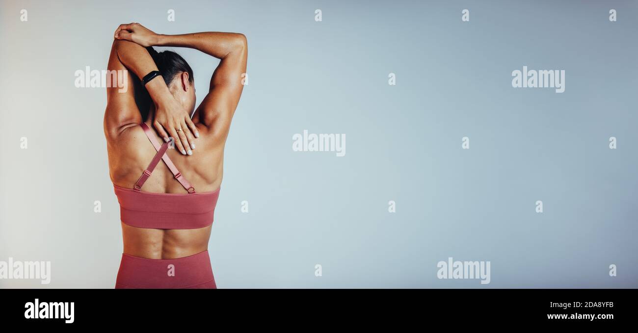 Rückansicht der Fitness-Frau dabei Arm Stretching Übungen. Weibliche Sportlerin beim Aufwärmen vor dem Training. Stockfoto