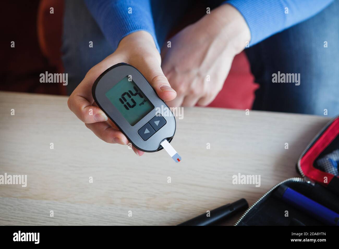 Frau, die den Glukosespiegel in ihrem Blut überprüft, gutes Ergebnis der Messung mit Glucometer Stockfoto