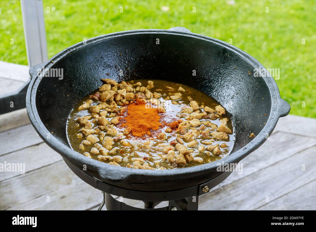 Fleisch und rote Paprika Kochen in Kessel auf Feuer im Freien für asiatische Gericht. Stockfoto