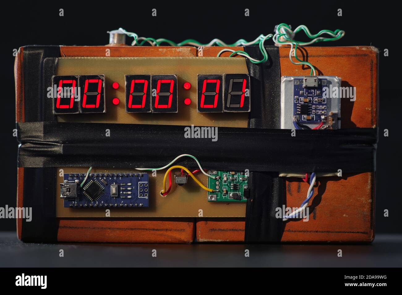 Bombe mit rotem Timer auf schwarzem Hintergrund. Improvisierte Sprengvorrichtung. Terroristische Bedrohung. Dynamit mit Uhrwerk. Sprengstoff mit Sprengkörper. Zeitbombe Stockfoto