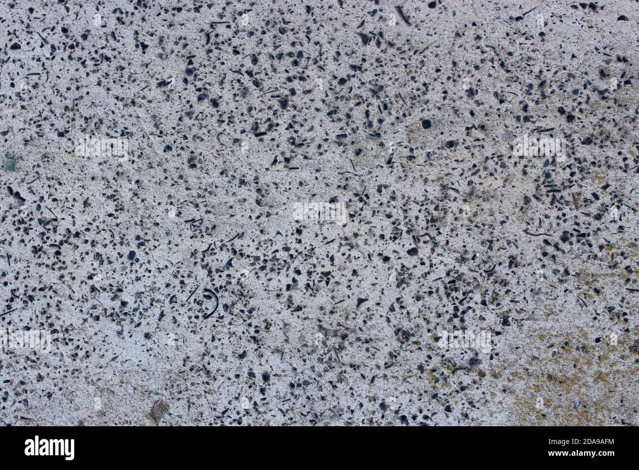 Struktur aus grauem Beton mit kleinen Steinen. Hintergrundbild von altem Zement Stockfoto