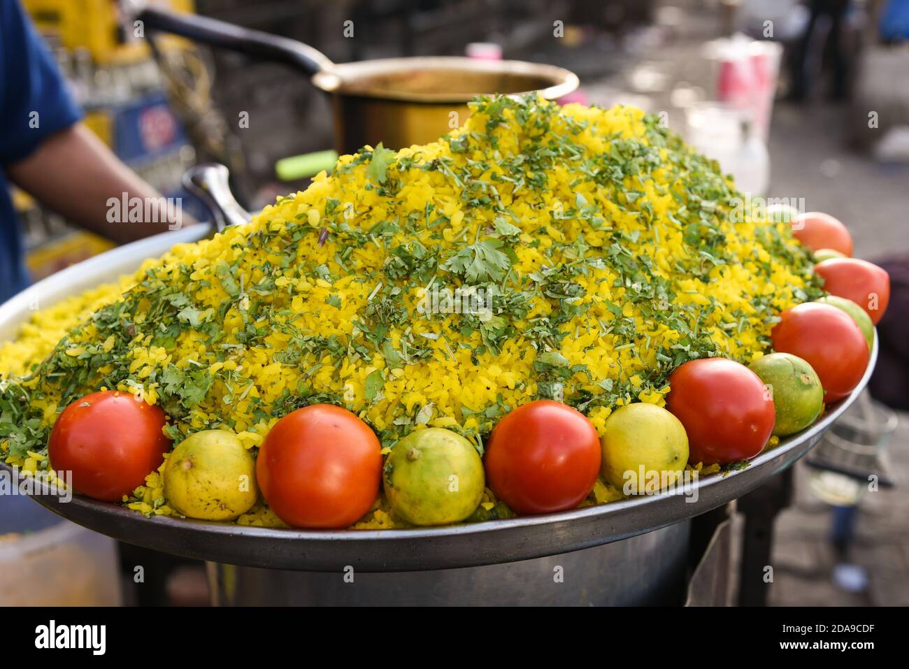 Indischer Mann verkauft Street Food Poha oder Zwiebelpohe beliebte traditionelle indische Lebensmittel Frühstück Gericht, Snack mit Reisflocken / geschlagener Reis gemacht. Stockfoto