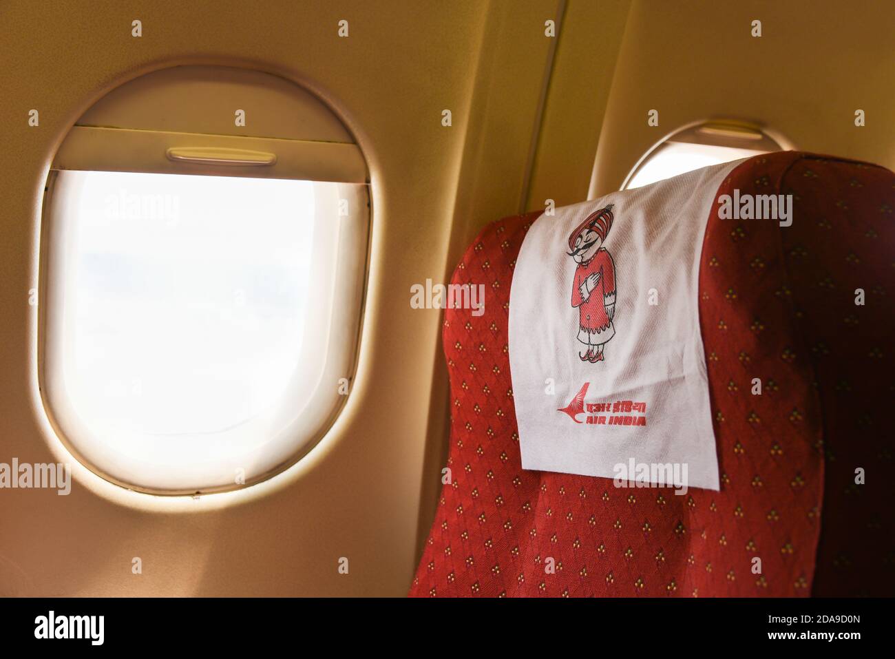 Kabine einer Air India (AI)-Maschine. Star Alliance Happy Indian Mädchen mit einem Flugzeug reisen. Kind sitzt am Flugzeugfenster Indien Stockfoto