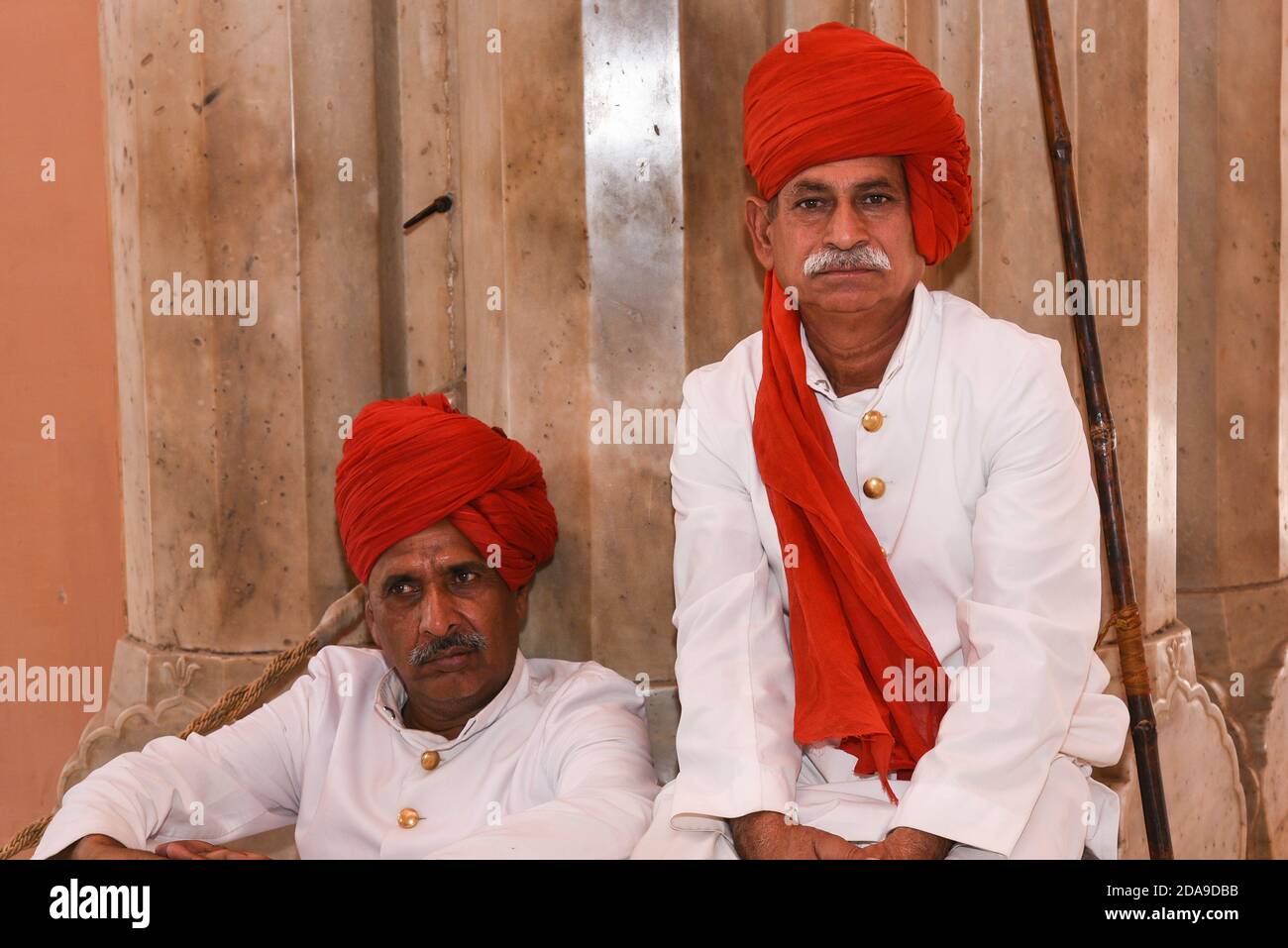 Indische Mann trägt traditionelle Kleidung roten Turban am Eingang des City Palace, Rajasthan, Nordindien. Stockfoto