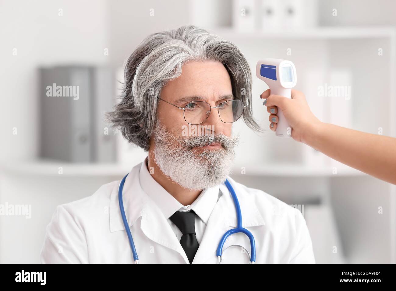 Messung der Temperatur des Arztes in der Klinik Stockfoto