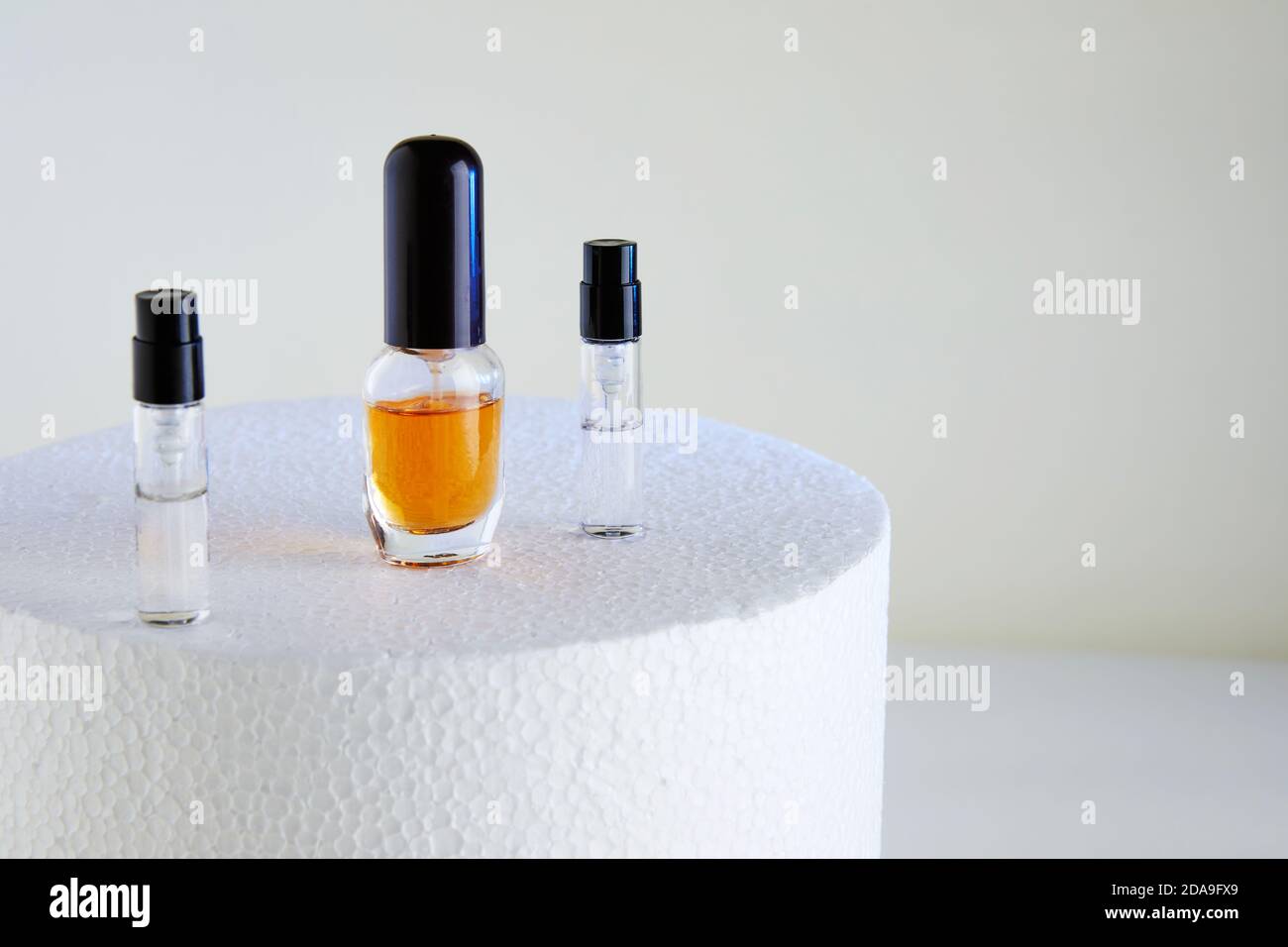 Tropfflasche für Parfümflaschen ohne Etiketten auf weißem Podium. Stockfoto