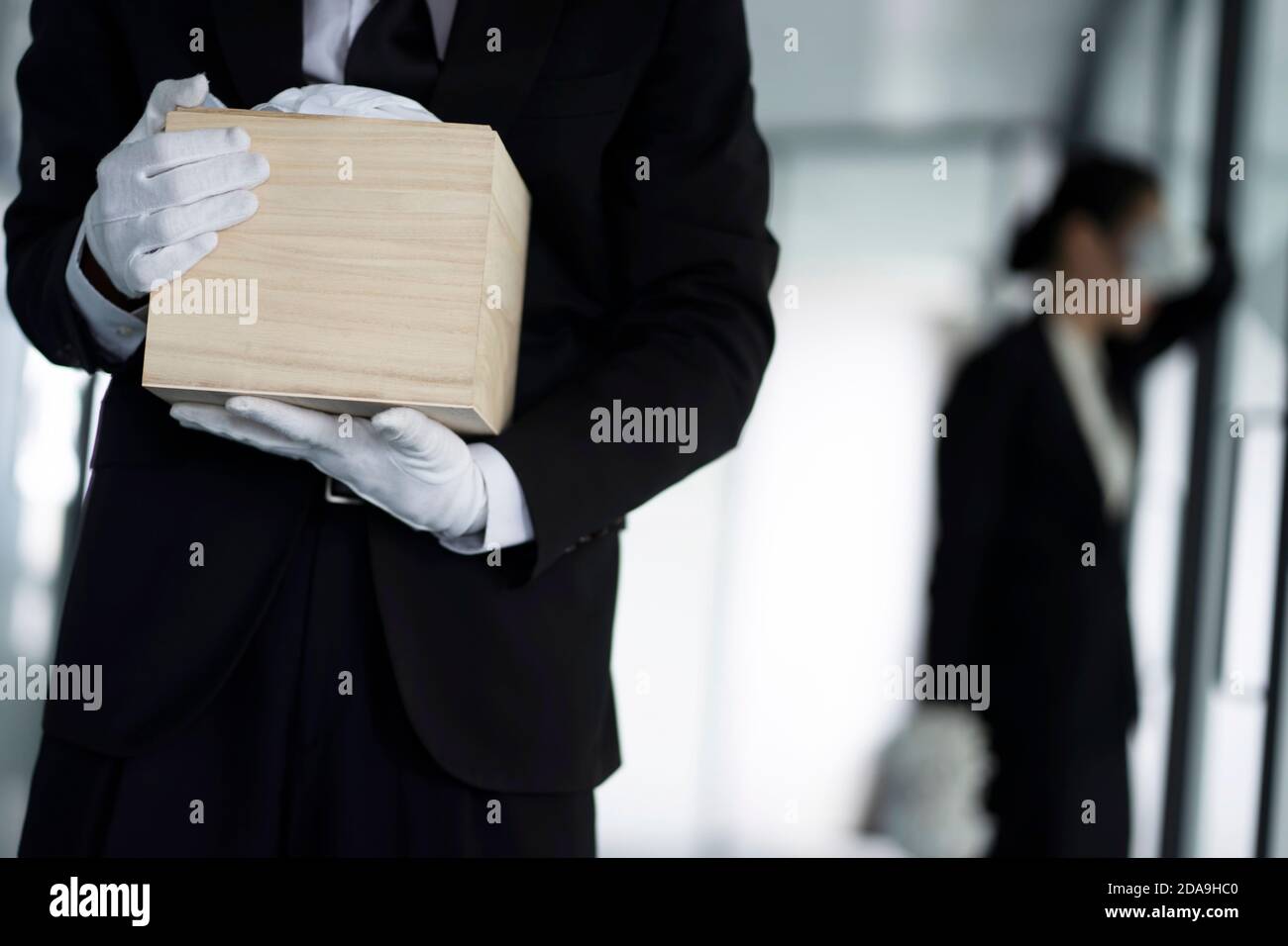Hinterbliebene halten Urne bei der Beerdigung Stockfoto