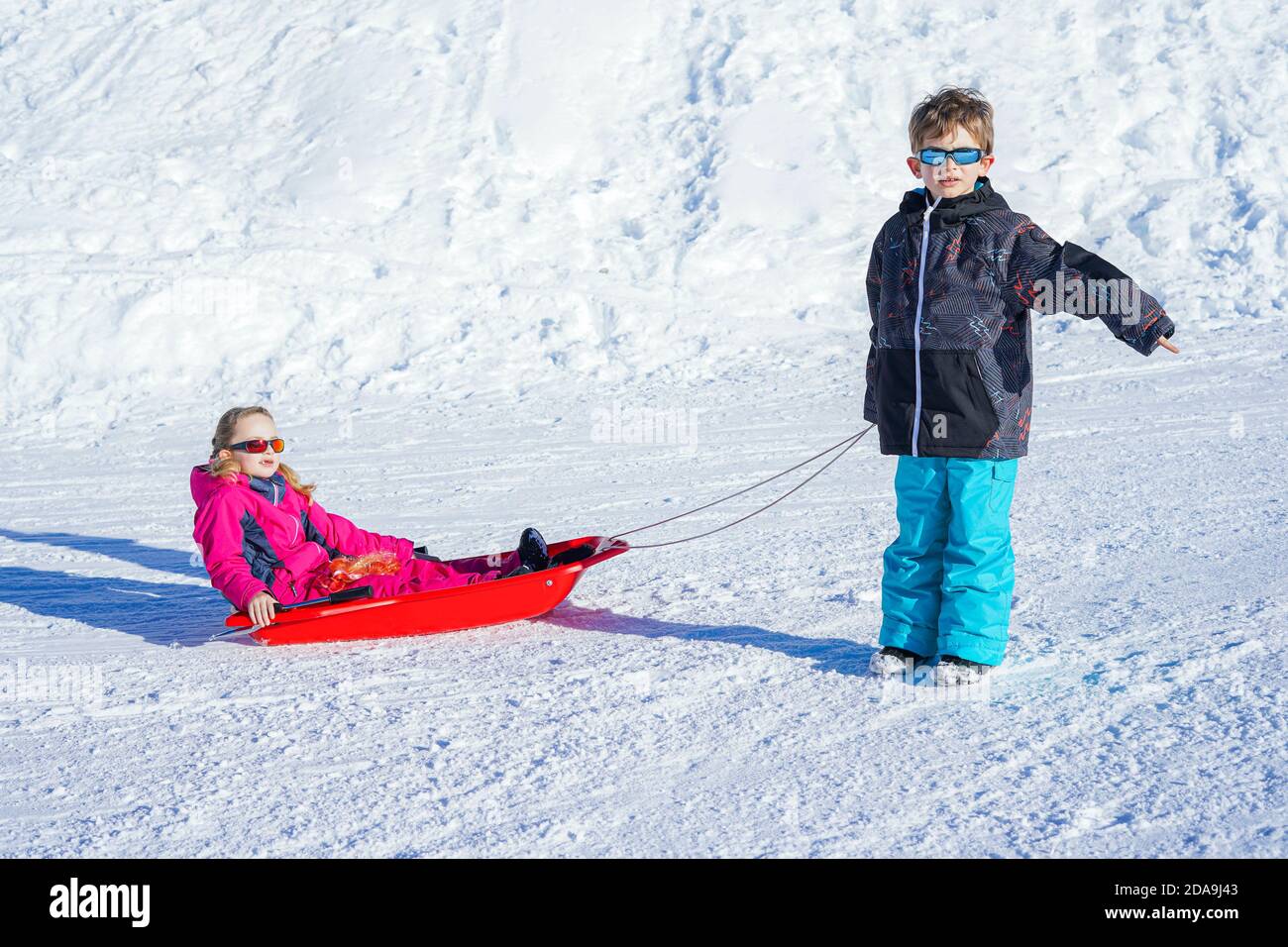 Bruder zieht seine Schwester Kinder Rodel Schlitten Schnee. Kleine