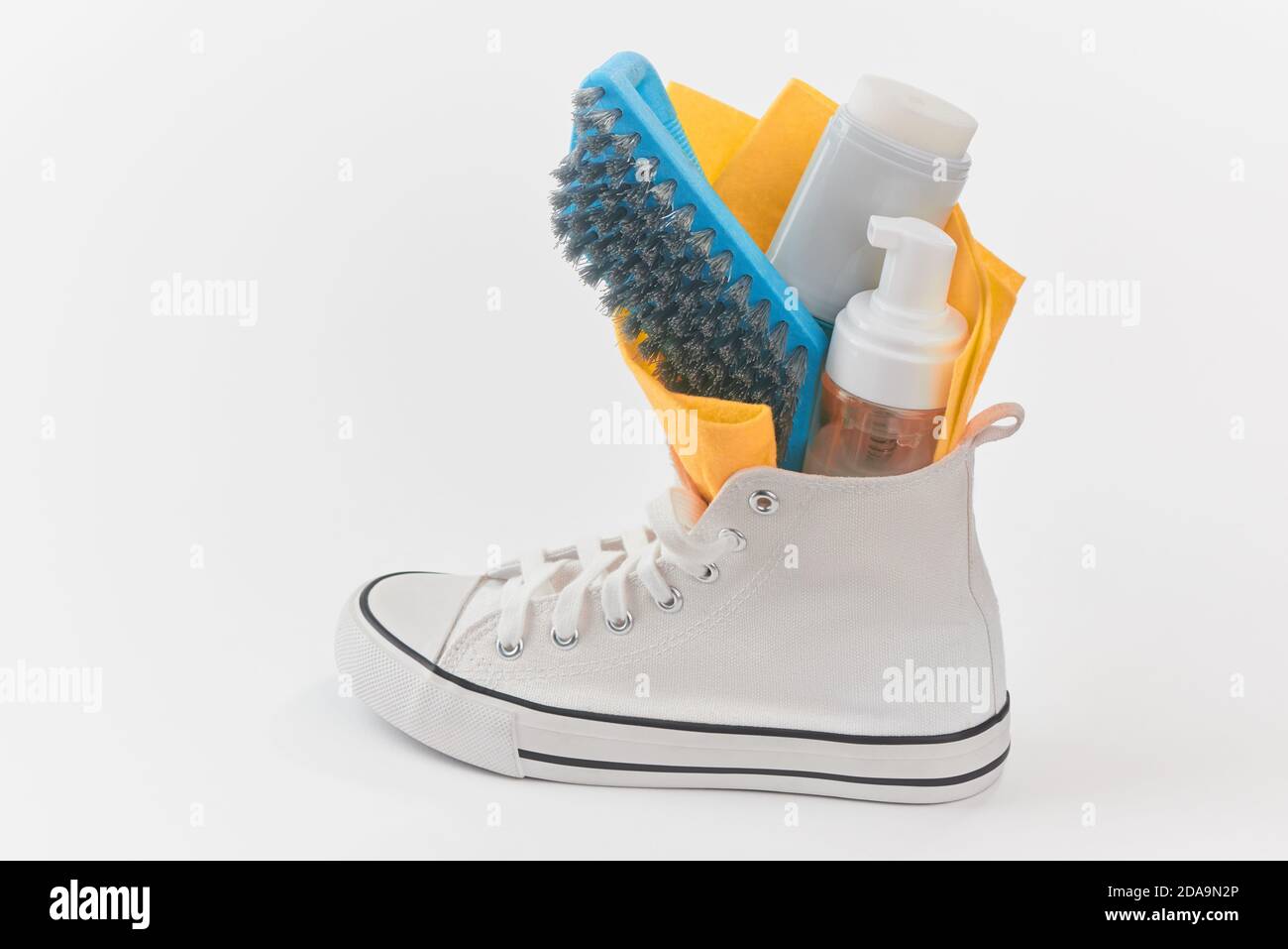 Reinigungsset in einem Segeltuch Sneaker auf weißem Hintergrund Stockfoto