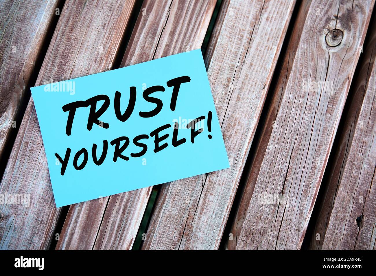 Vertrauen Sie sich selbst. Motivierendes oder inspirierendes Zitat handgeschrieben auf Papier auf einem Holztisch. Selbstvertrauenkonzept. Stockfoto