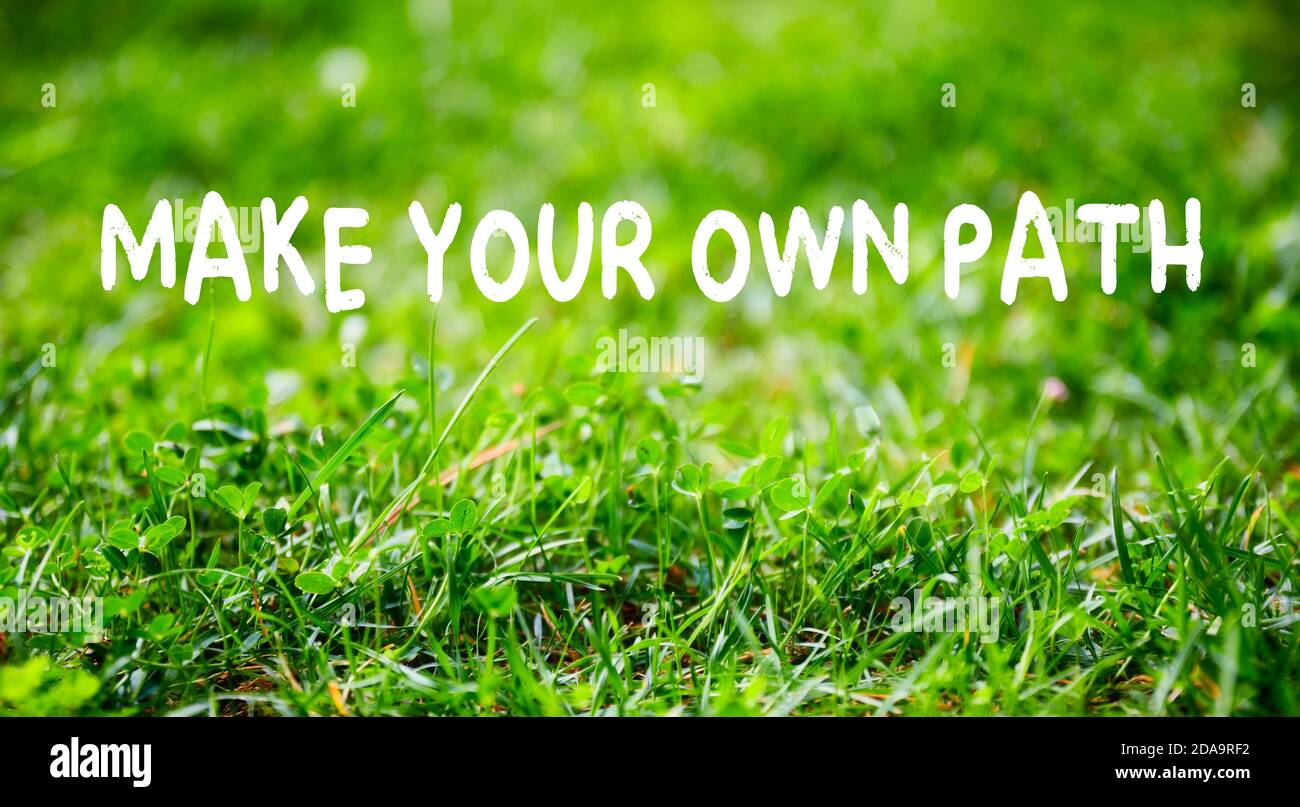 Motivationszitat Machen Sie Ihren eigenen Weg auf grünem Gras Garten Hintergrund. Individualität, Führung und das Finden eines einzigartigen Konzepts. Stockfoto