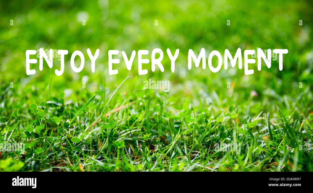 Inspirierende Lifestyle Zitat Genießen Sie jeden Moment auf grünem Gras Garten Hintergrund. Das Leben genießen und entspannen in der Natur Konzept. Stockfoto
