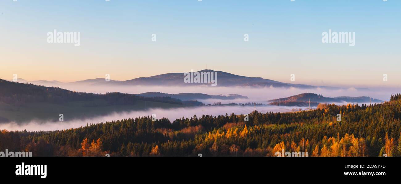 Neblige Landschaft bei Sonnenuntergang, Berge aus Nebelwolken im Hintergrund, klarer Himmel - Berg Klet, Tschechische republik Stockfoto
