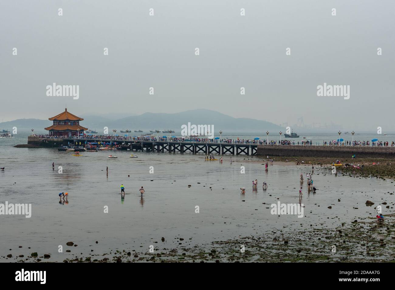 Qingdao / China - 5. August 2015: Der Zhanqiao Pier und der Huilan Pavillon erstrecken sich bis ins Meer entlang des südlichen Ufers der chinesischen Stadt Qingdao. Es ist appe Stockfoto