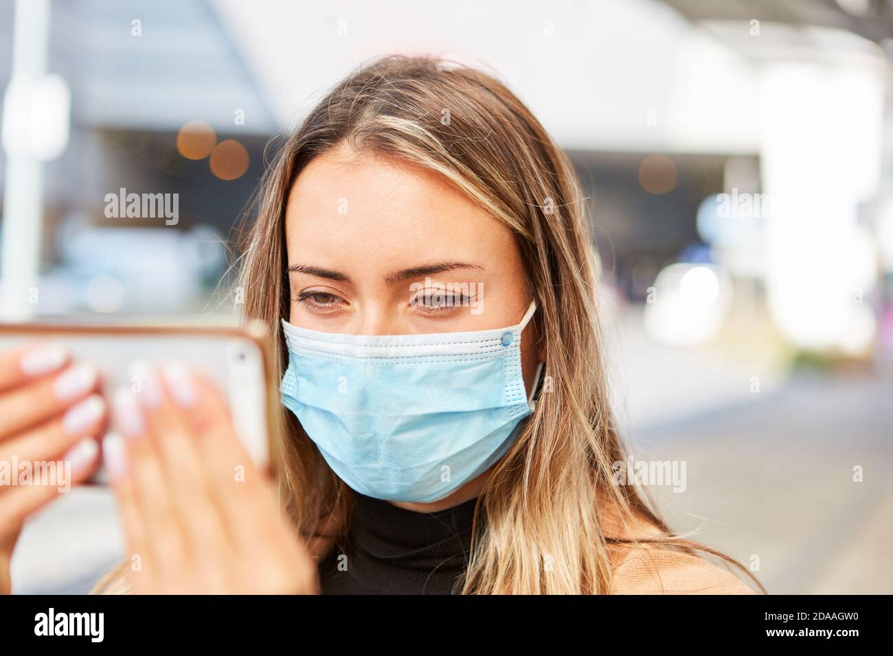 Ein Passant oder Tourist mit einer Gesichtsmaske nimmt ein Selfie während der Covid-19 Pandemie Stockfoto