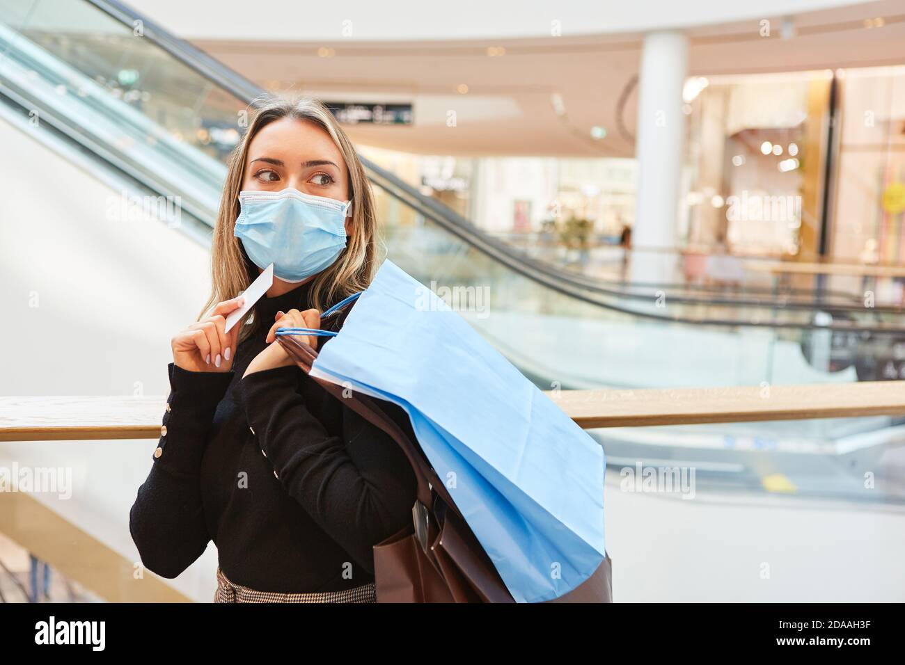 Kunde mit Gesichtsmaske aufgrund einer Covid-19-Pandemie beim Einkaufen Mit Kreditkarte Stockfoto