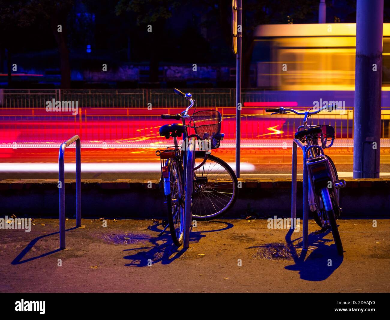 Zwei Fahrräder auf Stadtfahrrädern Parkplatz, Nacht Stadtszene Stockfoto