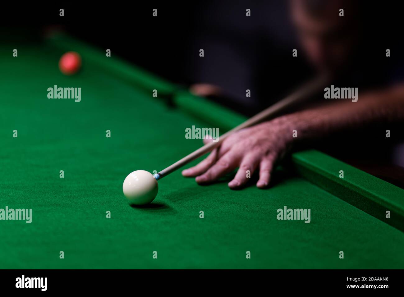 Mann, der versucht, den Ball im Billard zu schlagen. Geringer Fokus. Stockfoto