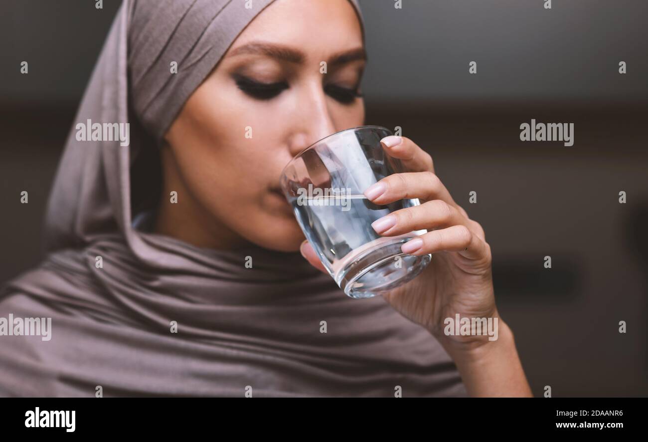 Porträt Der Arabischen Frau Trinkwasser Aus Glas In Der Küche Stockfoto