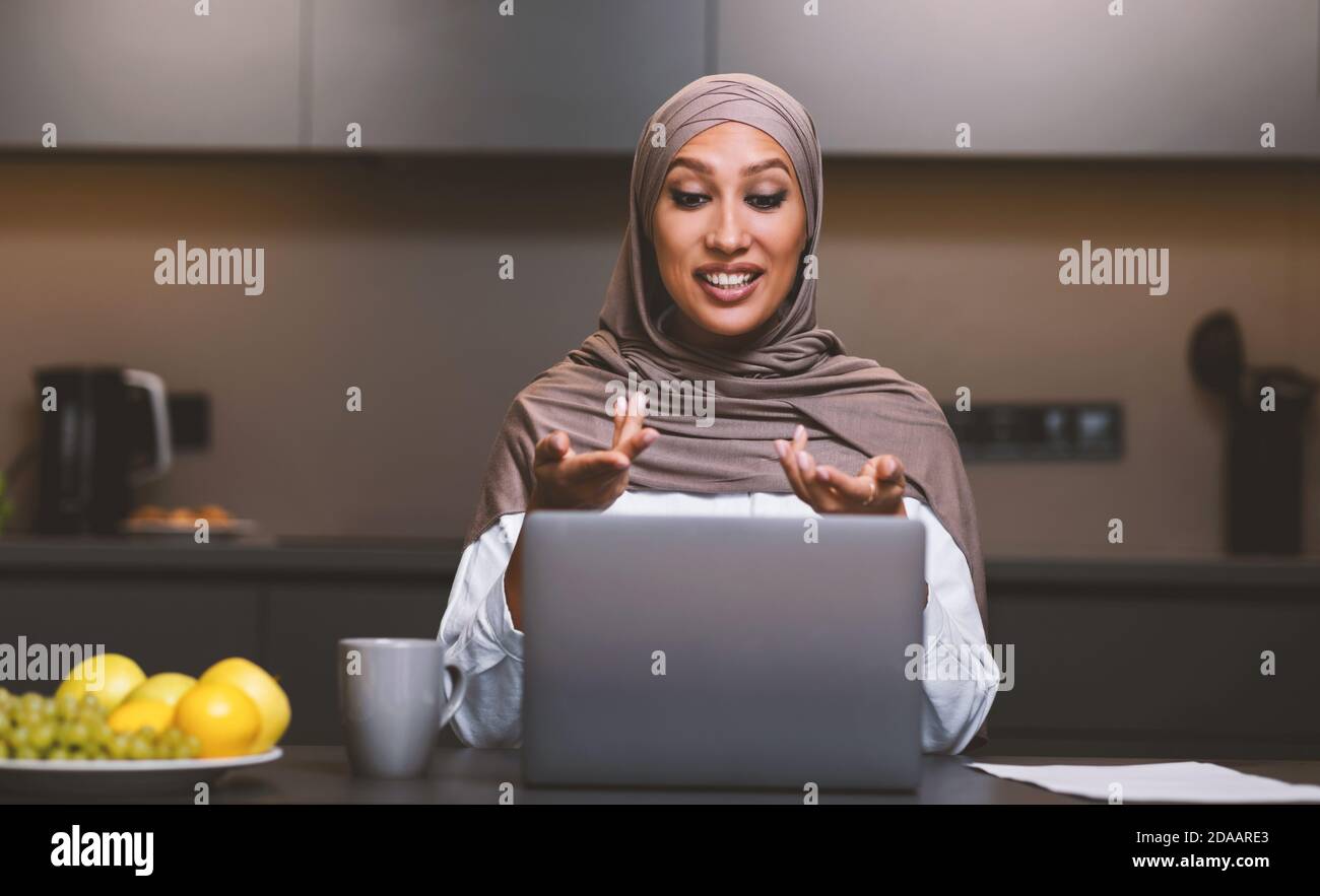 Arab Lady Machen Video Anruf Auf Laptop Online In Der Küche Stockfoto