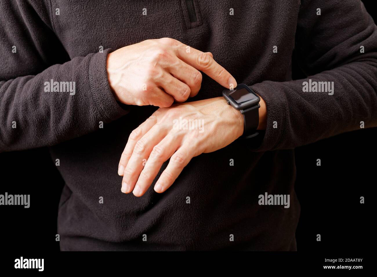 Nahaufnahme Hände von Mann mit seiner Smartwatch. Isoliert auf Schwarz. Stockfoto