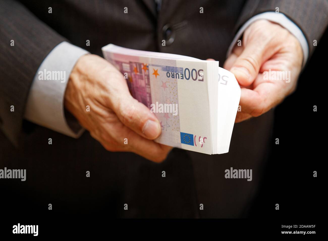 Ein Mann zählt das Geld in einem Geldbündel von 500 Euro. Geringer Fokus. Geschäfts- oder Finanzkonzept. Stockfoto