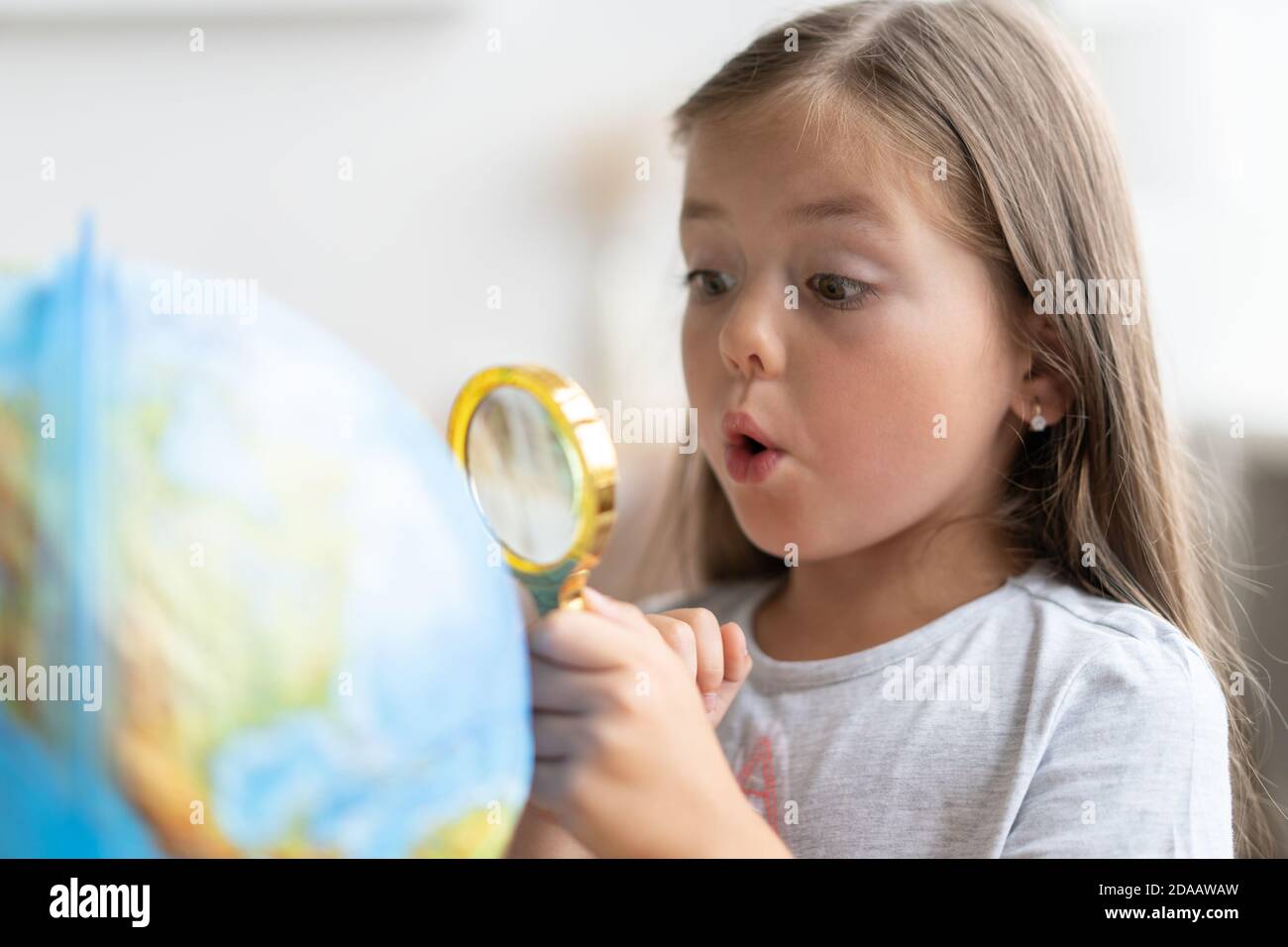 Bildung und Schulkonzept. Kind Mädchen zeigt auf den Globus. Stockfoto