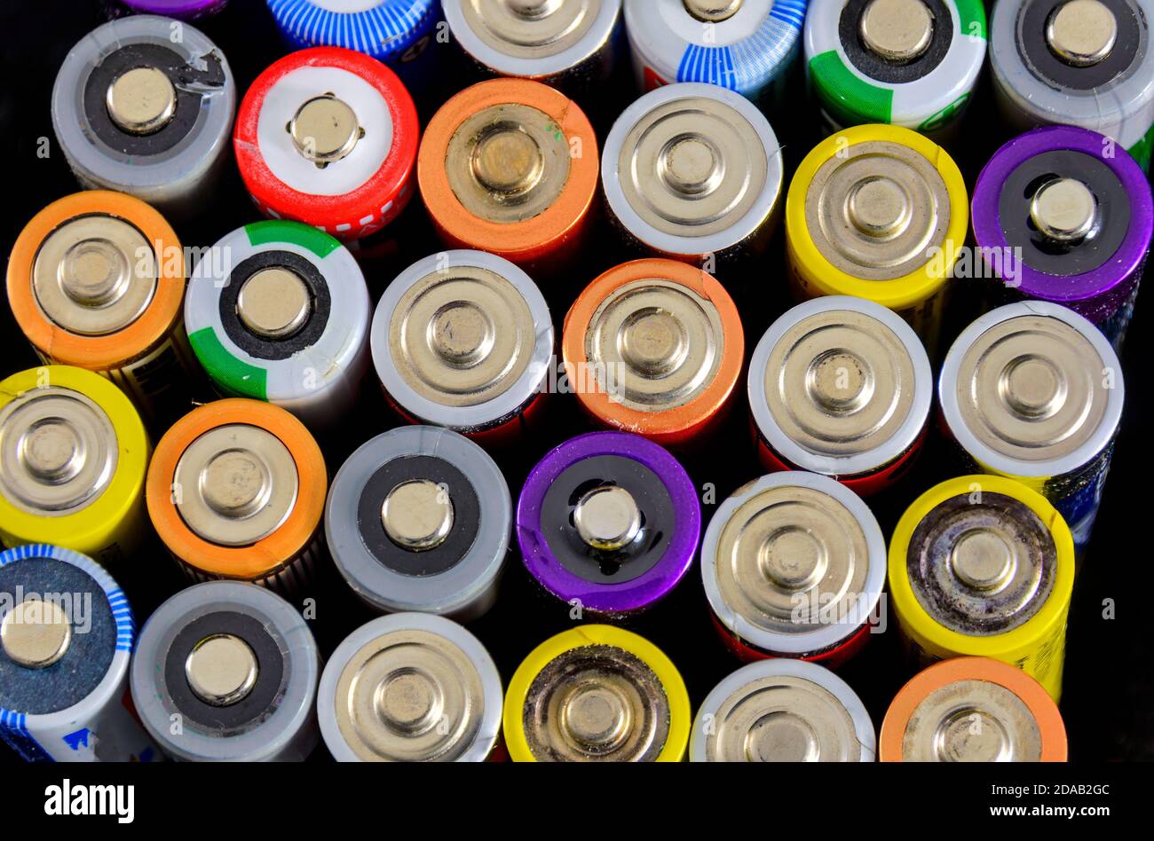 Positive Pole von alten Röhrenbatterien in verschiedenen Farben Stockfoto