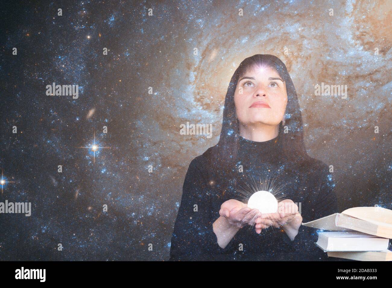 Ein Mädchen mit einem Stern in der Stirn hält einen leuchtenden Ball in den Händen und blickt auf den Sternenhimmel. Das Konzept der paranormalen Fähigkeiten, Hellsehen. Elemente dieses Bildes, die von der NASA eingerichtet wurden. Stockfoto