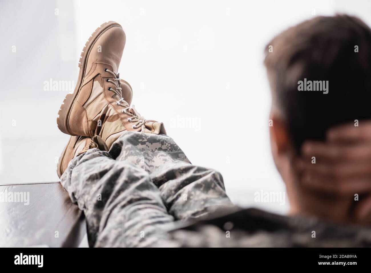 Militärische Stiefel auf Soldat ruht auf verschwommenem Vordergrund Stockfoto