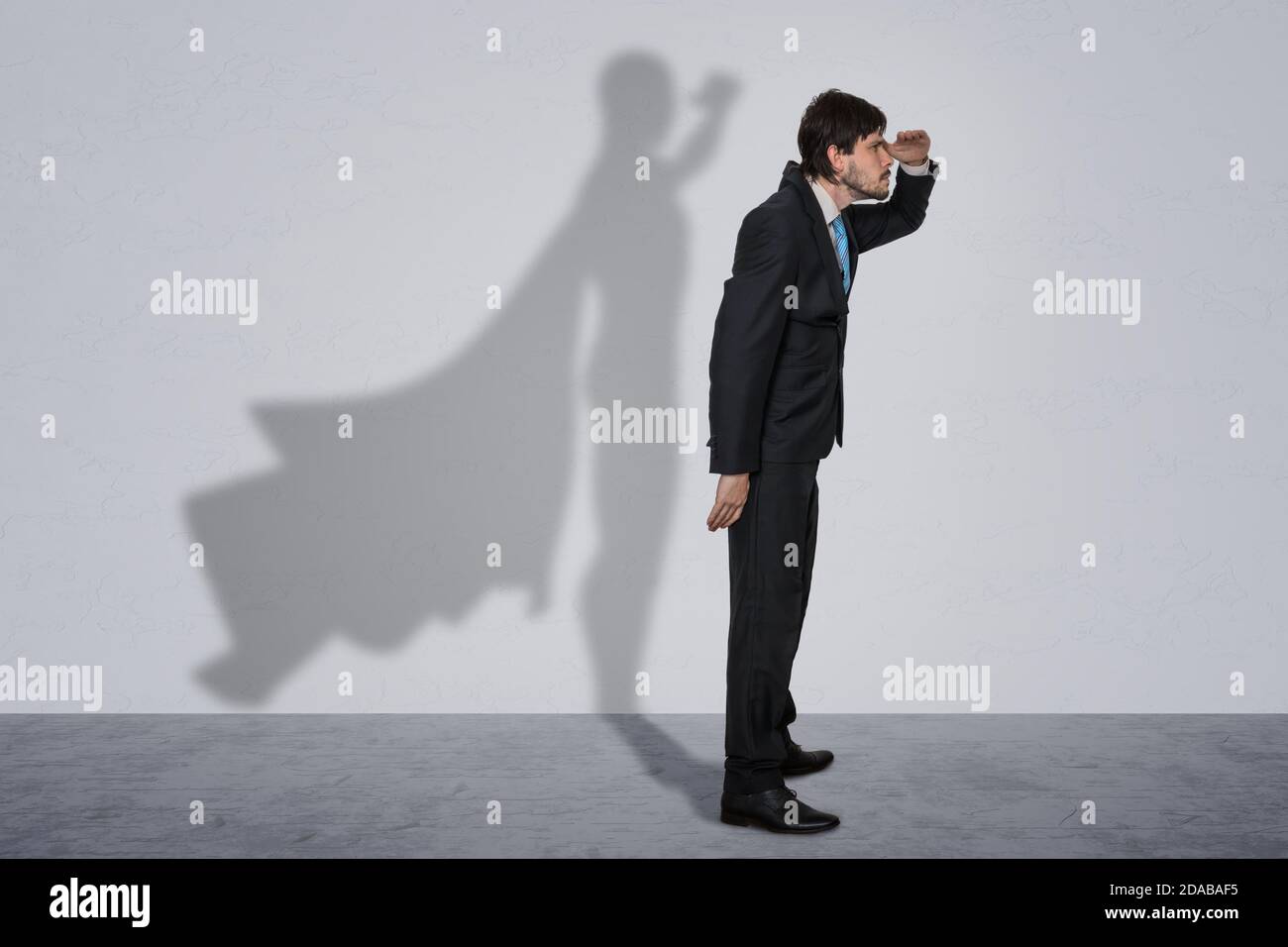 Geschäftsmann im Anzug mit Schatten als Superheld. Stockfoto