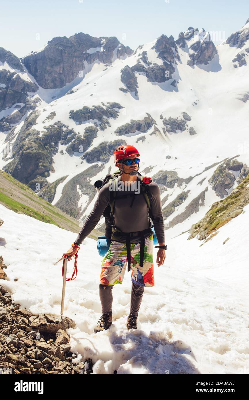 Mann mit einem großen Rucksack Bergsteiger Bergsteigen mit Eispickel In den Bergen Reise Lifestyle Endurance Konzept Abenteuer Aktivurlaub im Freien Klettern Stockfoto