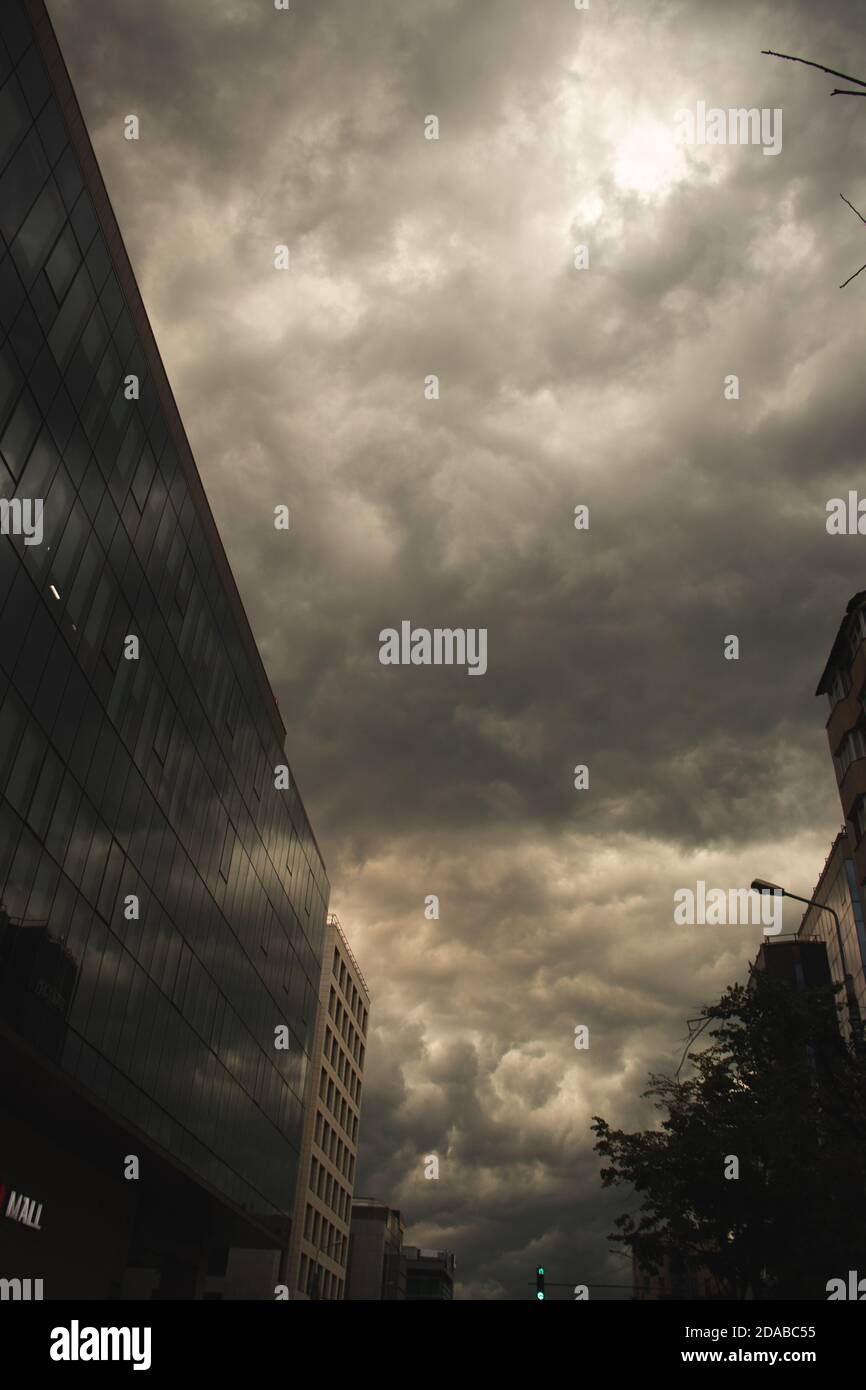 Stadtsturm, Verkehr, dramatische Wolken als Hintergrund, gelbes Licht Stockfoto
