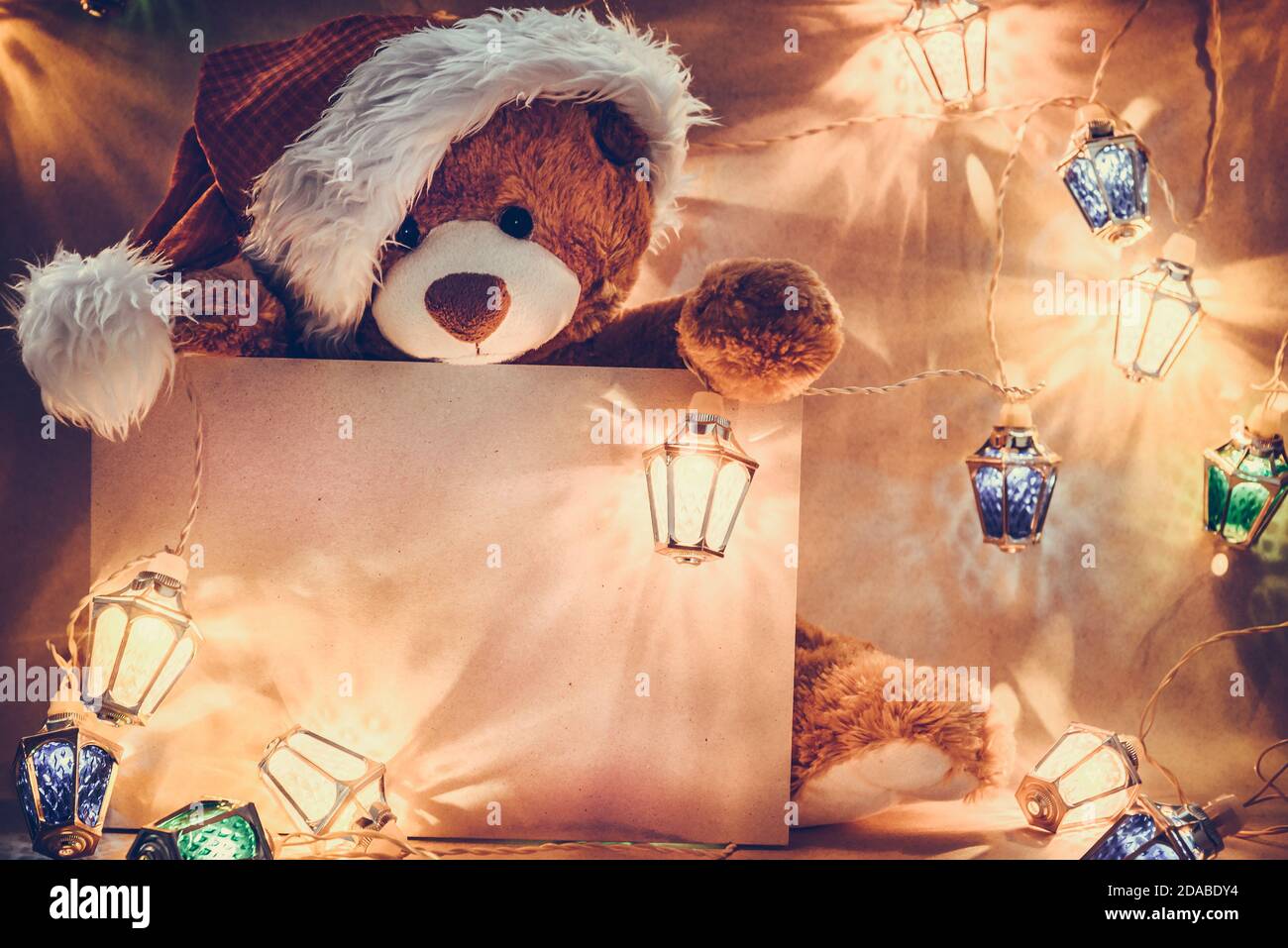 Weihnachtskarte mit Teddybär-Geschenken und Lichterketten Girlande. Stockfoto