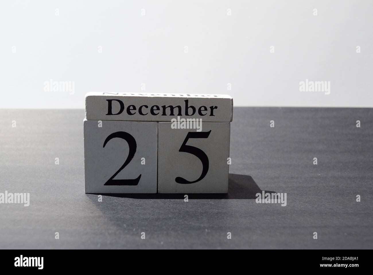 Weißer Würfel Nummer 25 und Dezember mit schwarz und weiß Hintergrund Stockfoto