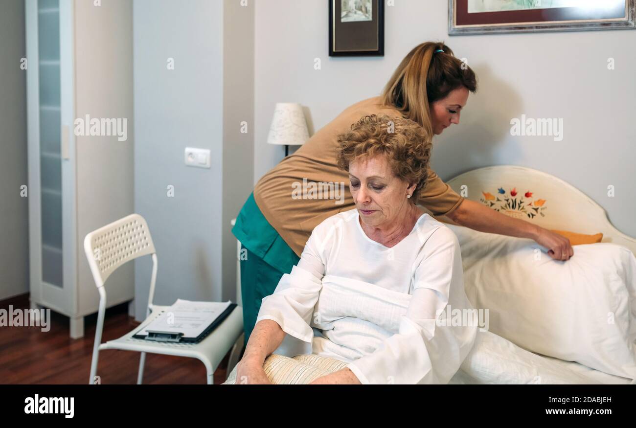 Pflegepersonal zur Unterbringung von Kissen für ältere Patienten Stockfoto