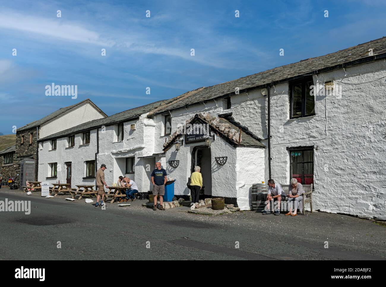 Menschen Touristen Besucher saßen im Sommer vor dem Kirkstone Pass Inn Pub Cumbria England Vereinigtes Königreich GB Großbritannien Stockfoto
