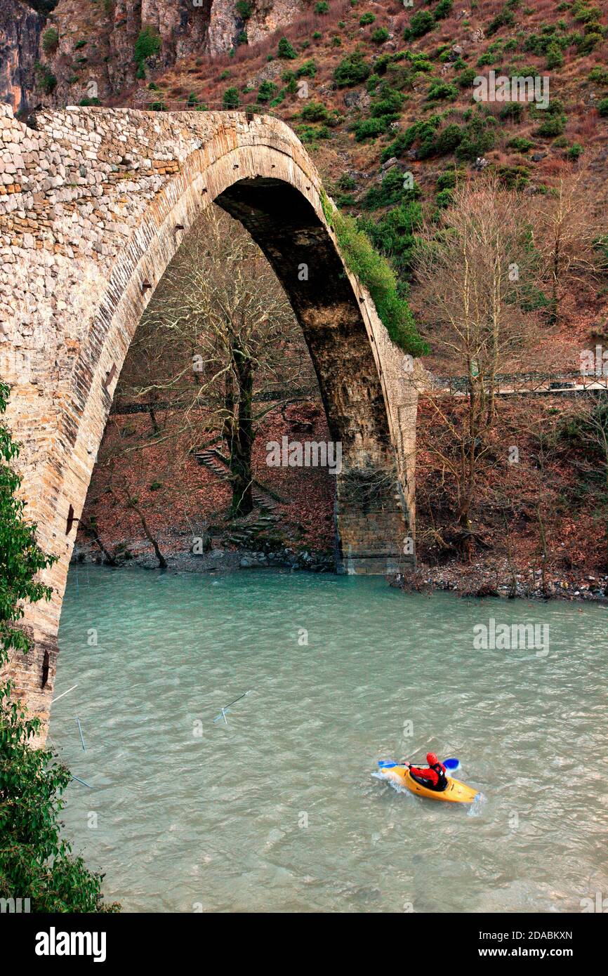 Kajak auf Aoos Fluss, unter der alten Steinbogenbrücke von Konitsa, Ioannina, Epirus, Griechenland. Stockfoto